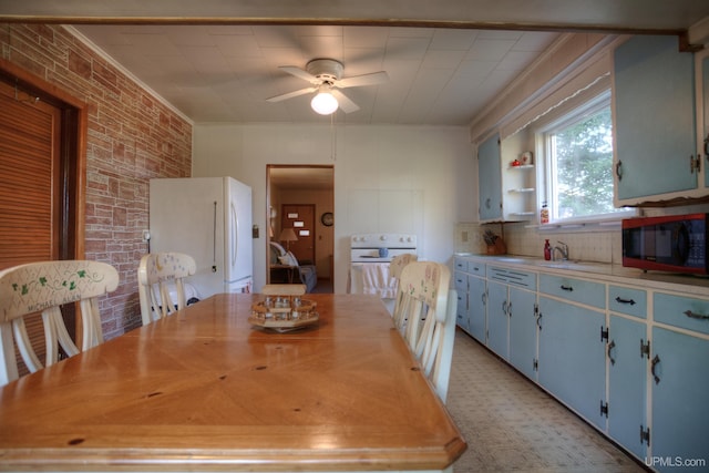 dining room with ceiling fan, brick wall, and crown molding