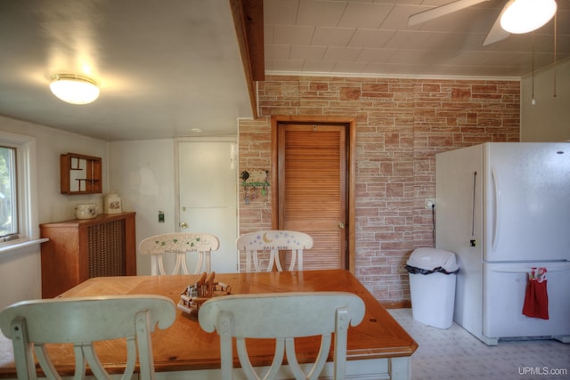 dining room with brick wall and ceiling fan