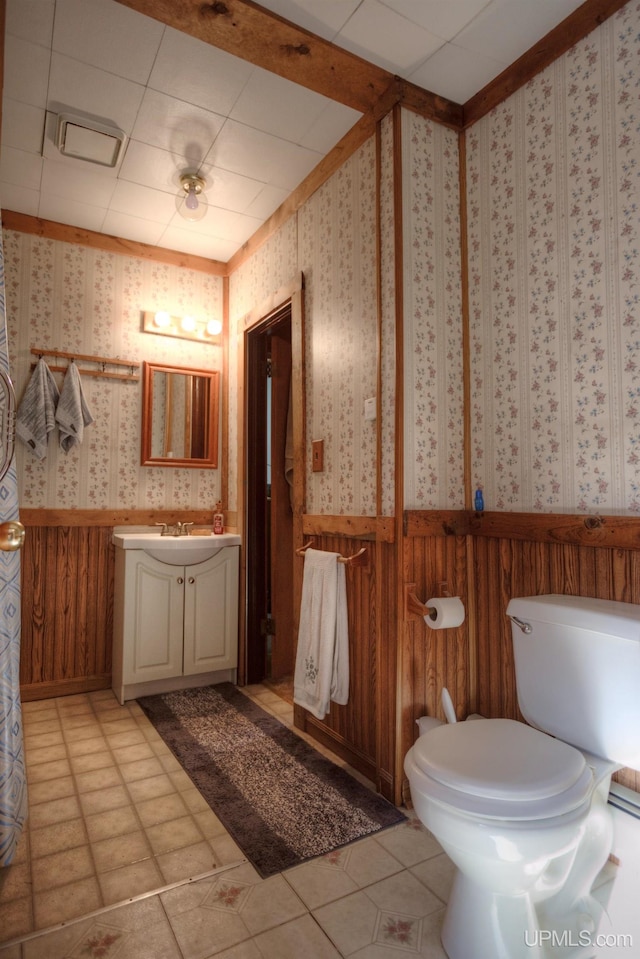 bathroom featuring vanity, a paneled ceiling, toilet, and wood walls