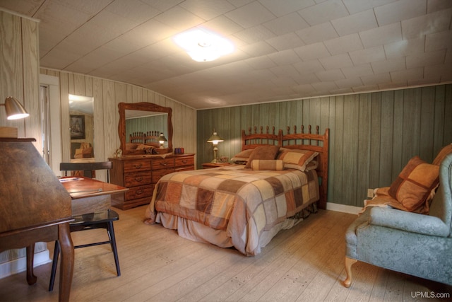 bedroom featuring hardwood / wood-style flooring and wood walls