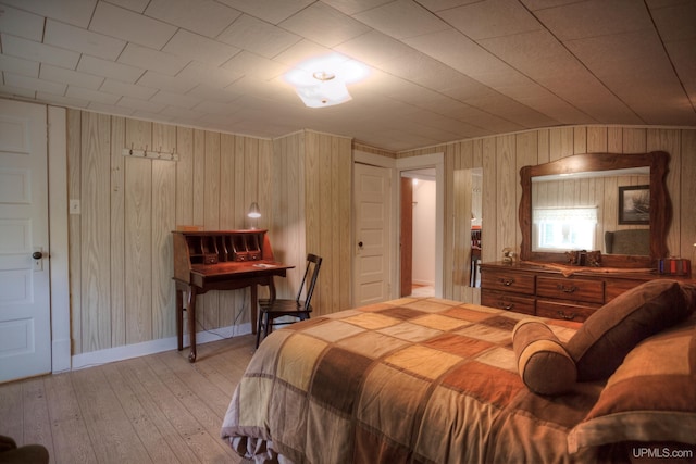 bedroom with hardwood / wood-style flooring and wooden walls