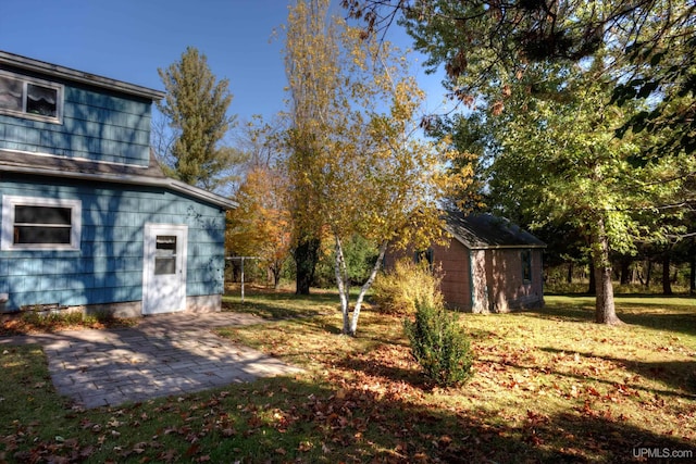 view of yard featuring a patio and a storage unit