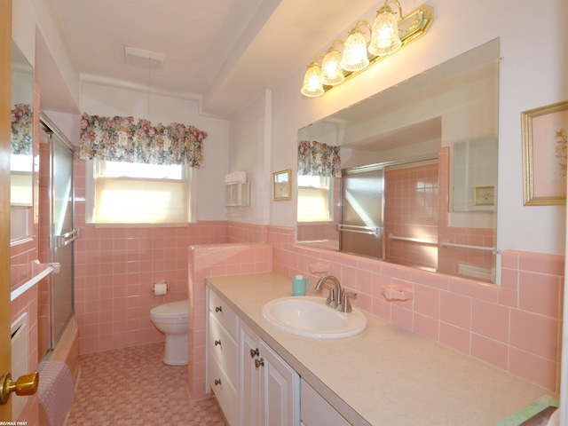 full bathroom featuring tile walls, vanity, shower / bath combination with glass door, and toilet