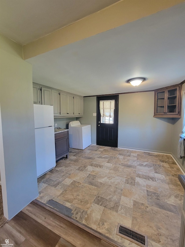 kitchen with washer / dryer, white fridge, and light hardwood / wood-style floors