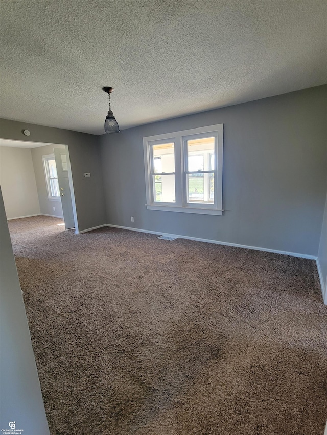 empty room featuring a textured ceiling and carpet floors