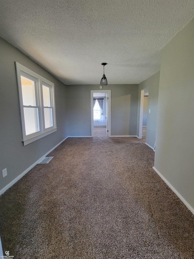 carpeted spare room with a textured ceiling