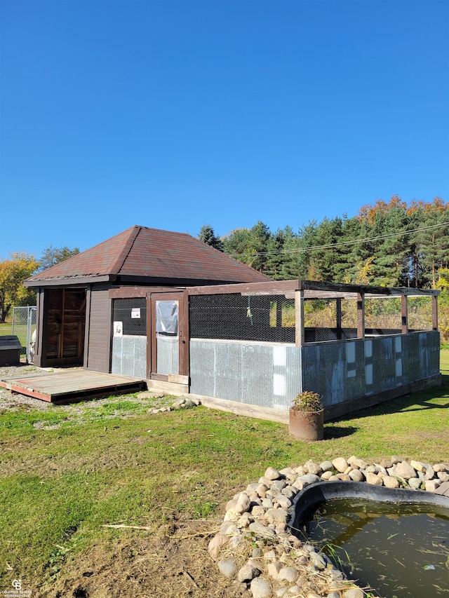 back of property with a lawn and an outbuilding