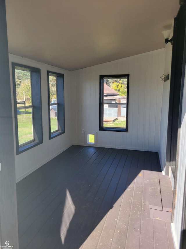 spare room featuring a wealth of natural light, lofted ceiling, and hardwood / wood-style flooring