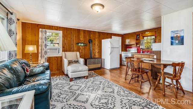 living room featuring wooden walls, cooling unit, and hardwood / wood-style flooring