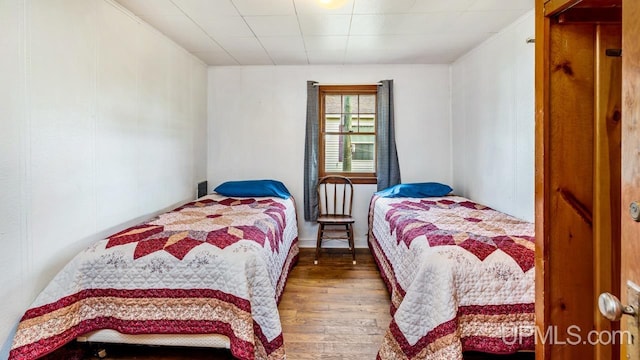 bedroom featuring crown molding and wood-type flooring