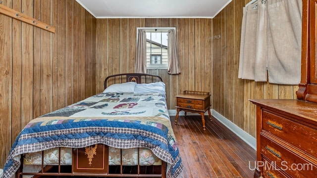 bedroom with dark hardwood / wood-style flooring and wooden walls