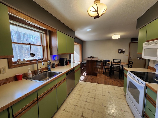 5206 Wolf Ln, Farwell, MI 48622 - kitchen featuring white appliances, green cabinetry, a sink, light countertops, and light flooring