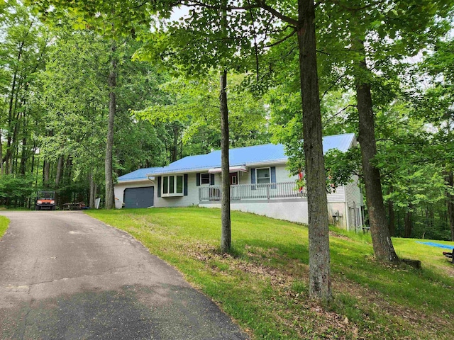 5206 Wolf Ln, Farwell, MI 48622 - ranch-style house with an attached garage, a front yard, covered porch, driveway, and metal roof