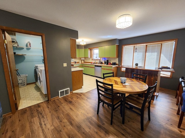 5206 Wolf Ln, Farwell, MI 48622 - dining space with independent washer and dryer, light wood finished floors, and baseboards