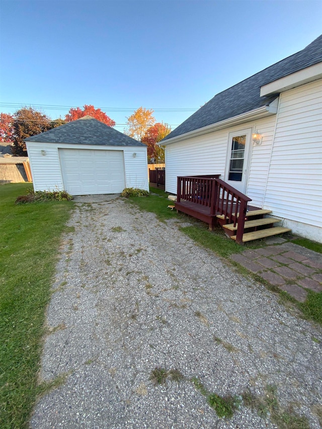 view of home's exterior with a yard, a garage, and an outbuilding