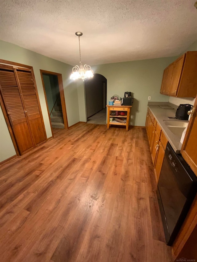 dining area with light hardwood / wood-style floors, a notable chandelier, and a textured ceiling