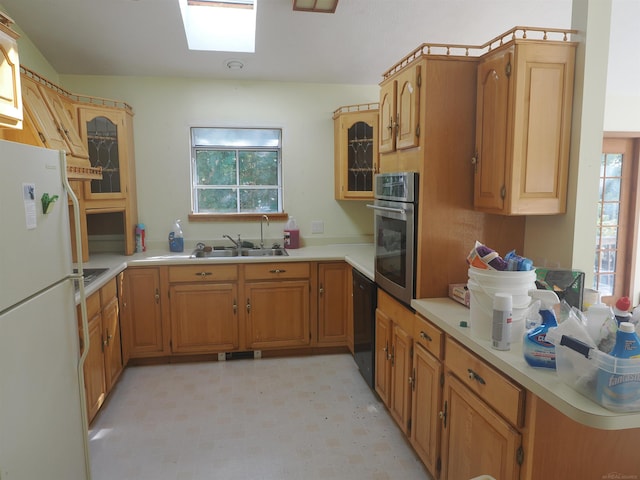 7502 Kauffman Blvd, Presque Isle, MI 49777 - kitchen featuring stainless steel oven, freestanding refrigerator, a skylight, a sink, and light floors