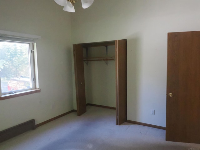 unfurnished bedroom featuring light colored carpet, a closet, and ceiling fan