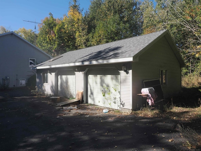 view of side of home featuring an outbuilding and a garage