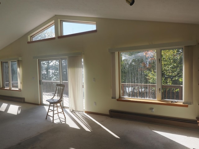 interior space with a healthy amount of sunlight, lofted ceiling, and a baseboard heating unit