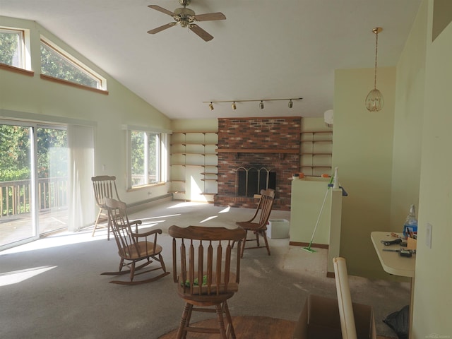 dining area with ceiling fan, high vaulted ceiling, wood-type flooring, and a brick fireplace