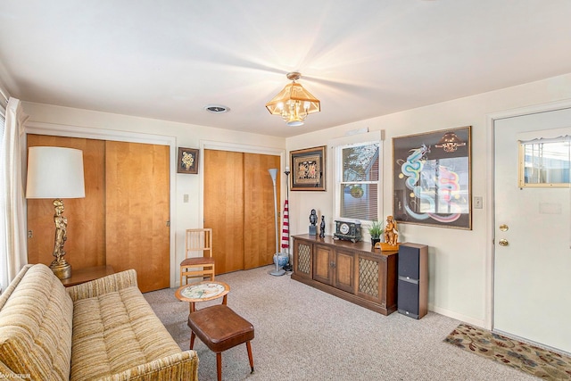 living room with a notable chandelier and light colored carpet