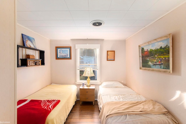 bedroom featuring wood-type flooring and ornamental molding