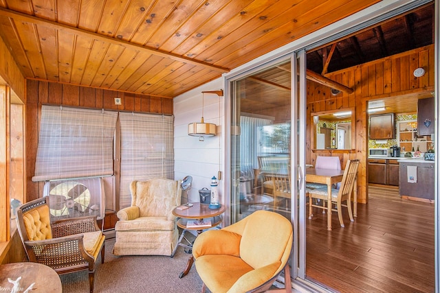 sitting room featuring hardwood / wood-style flooring, wooden ceiling, and wooden walls