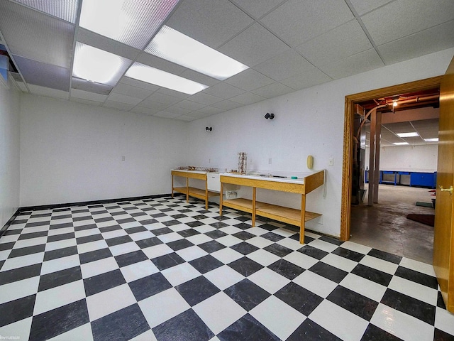 basement with a paneled ceiling and a workshop area