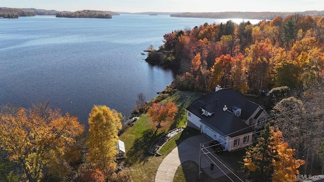 aerial view with a wooded view and a water view