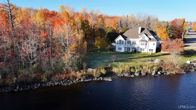 drone / aerial view featuring a wooded view and a water view