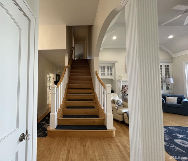 staircase with ceiling fan, arched walkways, hardwood / wood-style floors, and recessed lighting