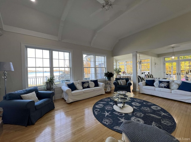 living area with vaulted ceiling, hardwood / wood-style flooring, ceiling fan, french doors, and ornate columns