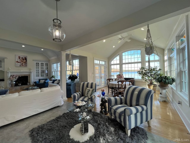 living room featuring vaulted ceiling with beams, ceiling fan, a water view, and light hardwood / wood-style floors