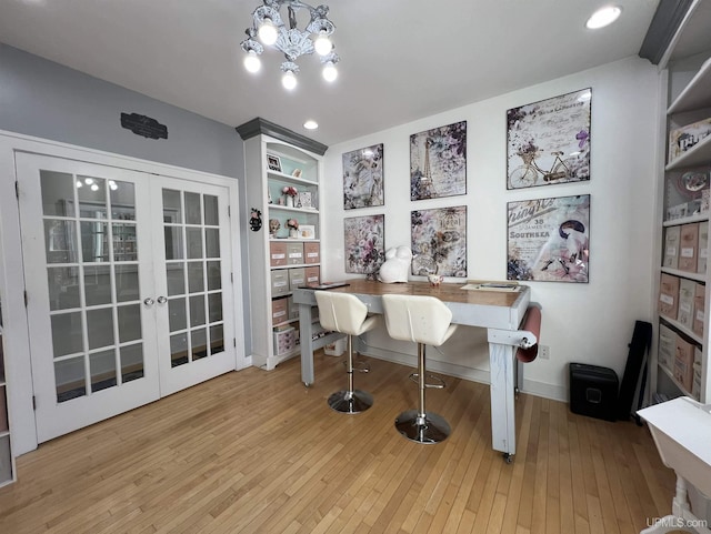 office area with hardwood / wood-style floors, french doors, baseboards, a chandelier, and built in shelves