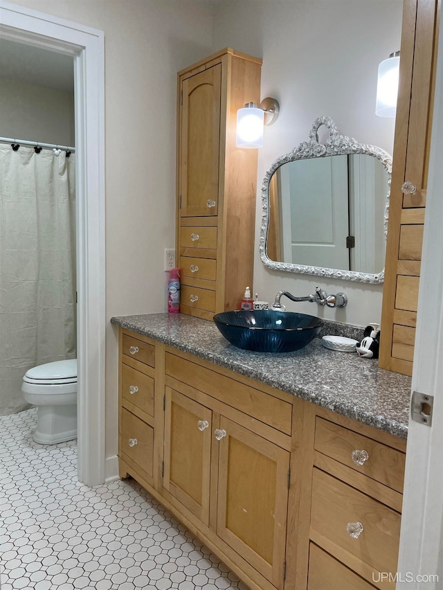 bathroom with vanity, toilet, and tile patterned flooring