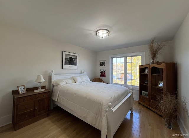 bedroom with light wood-style flooring and baseboards