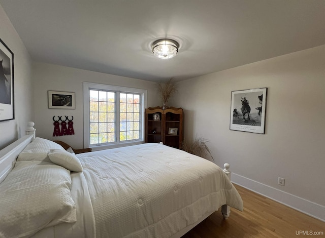 bedroom featuring baseboards and wood finished floors