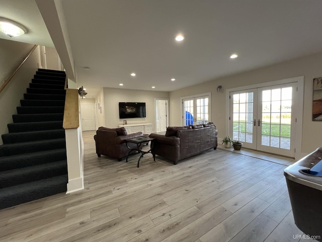 living room featuring light wood-type flooring, french doors, recessed lighting, and stairs