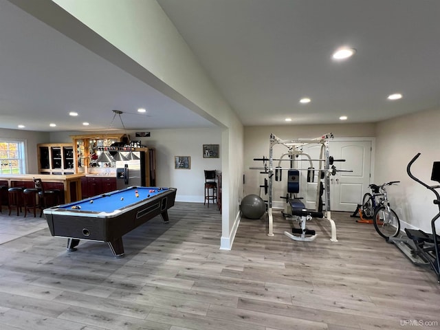 playroom featuring pool table, light hardwood / wood-style flooring, and indoor bar