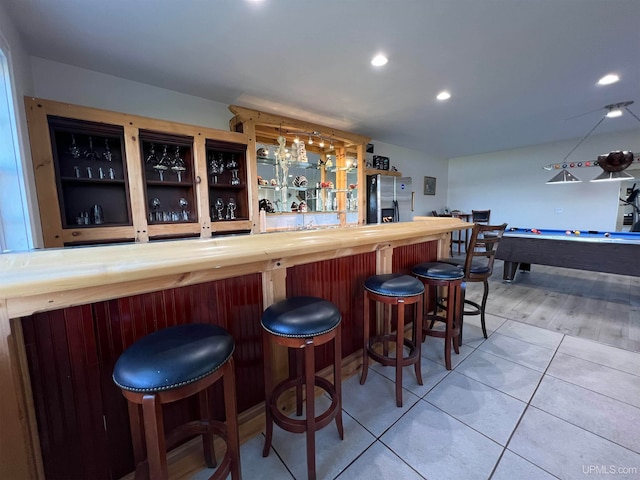 bar with stainless steel fridge, billiards, wood-type flooring, and butcher block countertops