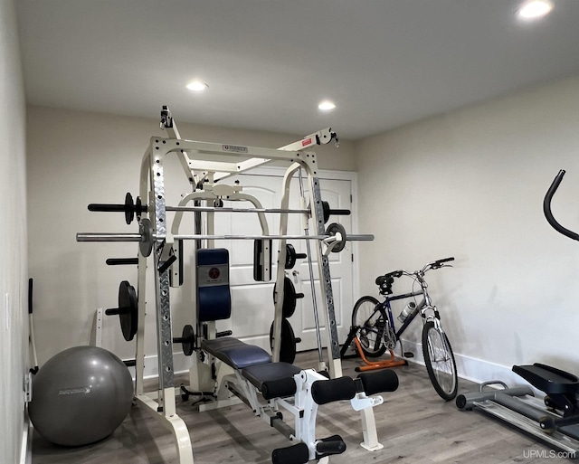 workout room with baseboards, wood finished floors, and recessed lighting