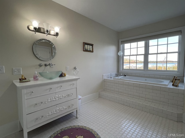 bathroom with a bath, vanity, and baseboards
