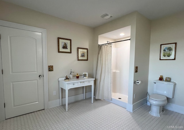 bathroom featuring toilet and walk in shower