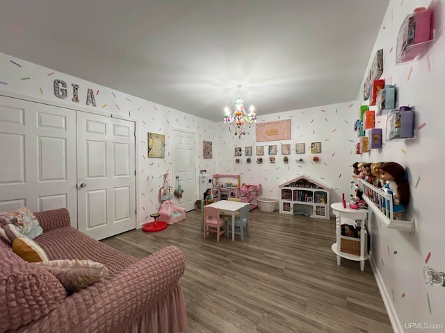 recreation room featuring a notable chandelier and dark hardwood / wood-style flooring