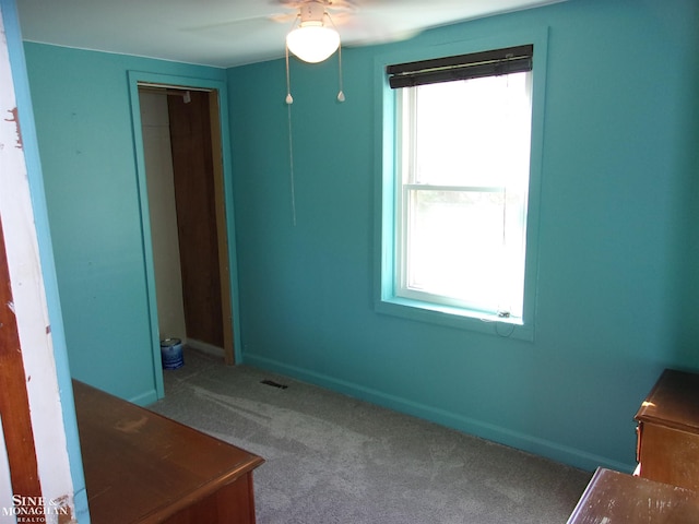 unfurnished room with ceiling fan, carpet floors, and plenty of natural light