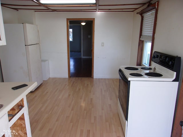 kitchen featuring a wealth of natural light, light wood-type flooring, and white appliances