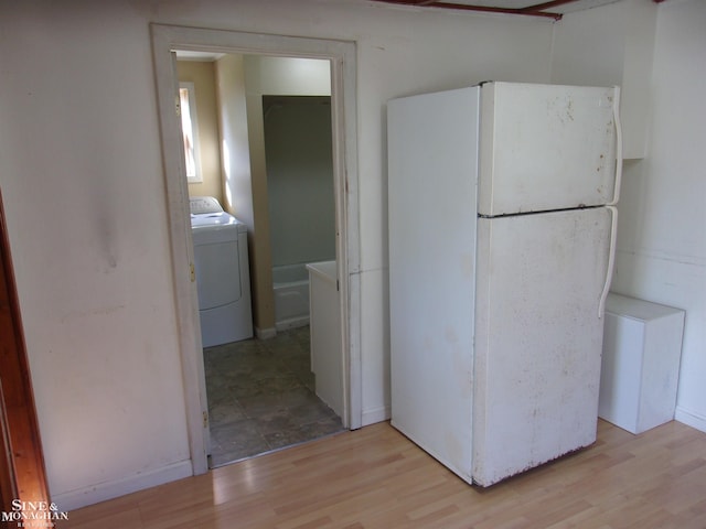 kitchen with washer / dryer, light wood-type flooring, and white refrigerator