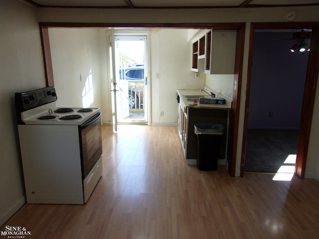 kitchen featuring sink, white electric range, and light wood-type flooring