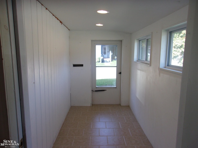 entryway featuring wooden walls and tile patterned flooring